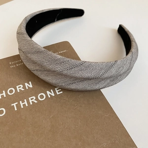 Detailed macro view of the grey herringbone fabric texture on the wide-brimmed headband