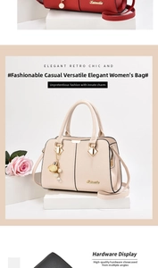 Détail du sac à main en cuir grainé avec poignées renforcées et breloque flacon de parfum