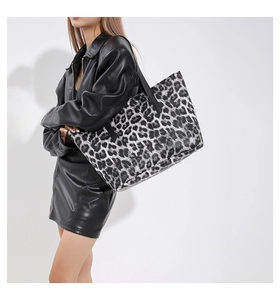 Elegante borsa tote con stampa leopardata bianca e nera mostrata da una modella