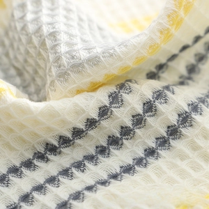 Macro view of waffle weave texture on soft cotton face towel with geometric patterns