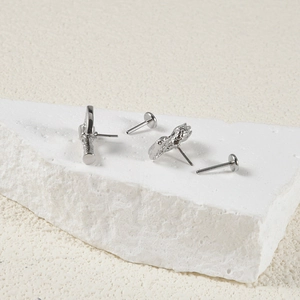 Macro shot of silver stainless steel push-in labrets with sword and wrench designs