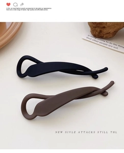 Close-up of matte black and coffee brown long stream-lined banana hair clips