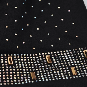 Detailed view of black knitted hat featuring sparkling blue rhinestones and crystal accents