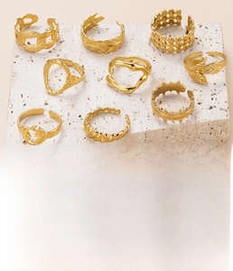 Detailed view of nine gold-plated stainless steel rings with unique vintage leaf textures