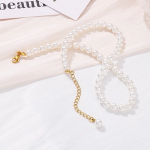Elegant French style pearl choker necklace with gold clasp on minimalist light fabric