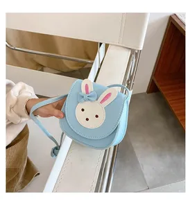 Detailed view of light blue leather crossbody bag for kids with white bunny patch
