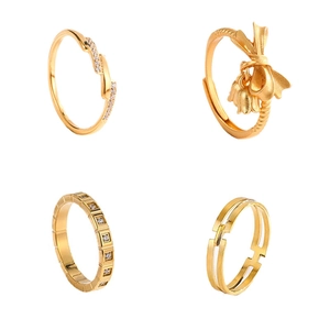 Set of four gold titanium steel rings with bow and geometric diamond designs