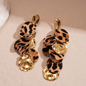 Detail of bohemian gold hammered metal discs and leopard print leather drop earrings
