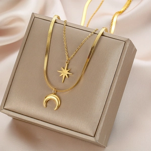 Minimalist double-layered gold necklace with star and crescent moon pendants on silk
