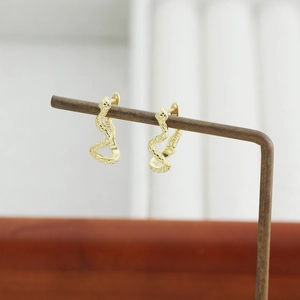 Macro detail of S925 silver snake hoop earring showing scale texture and gold plating