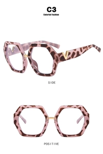 Detailed view of pink tortoiseshell glasses frame with golden V-shaped temple accents