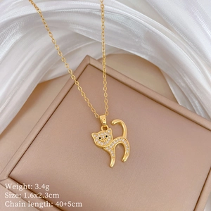 Close-up of gold cat pendant with pavé crystals on white silk and jewelry box