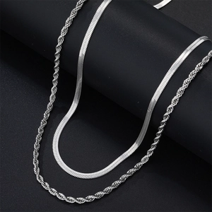 Detailed macro view of silver layered snake chain and rope chain necklace with metallic luster