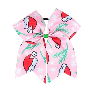 Detailed view of pink Christmas bow hair tie with festive hat and snowflake patterns