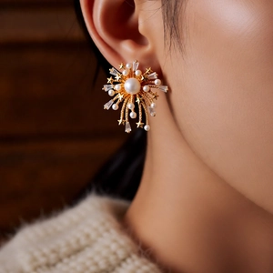 Close-up of 18k gold plated firework stud earring with pearl and zircon on model