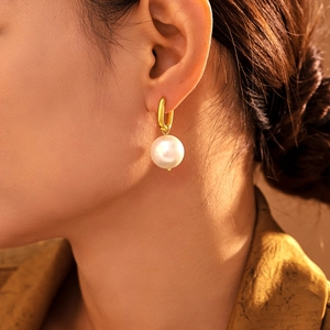 U-shaped stainless steel gold earrings featuring a large elegant white pearl drop