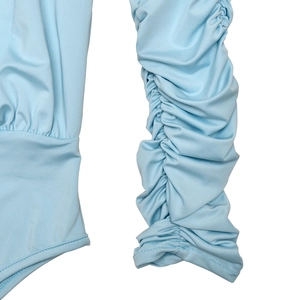 Detailed view of ruched long sleeves and stitching on a light blue bodysuit