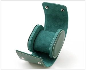 Detail view of green leather watch box with white stitching and silver metal snap closure