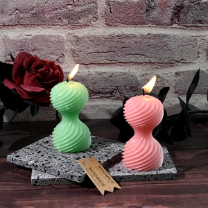 Candele profumate a spirale nei colori verde e rosa su vassoio in pietra decorativa