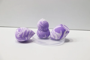 Detailed view of three purple marble makeup sponges in teardrop and slanted cut shapes