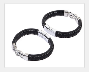 Gros plan de bracelets en cuir tressé noir avec fermoir magnétique en argent gravé