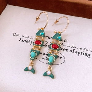 Detailed view of vintage fish tassel earrings with green enamel and colorful bead inlay