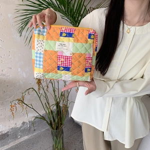 Floral quilted makeup bag with multi-color patchwork patterns and soft cotton texture
