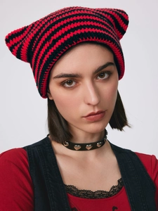 Close-up of red and black striped knitted cat ear beanie with chunky crochet texture