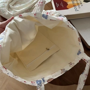 Detail view of the quilted tote bag interior featuring a secure zipper pocket and canvas lining
