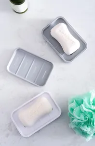 Close-up of double-layer self-draining soap holder with minimalist gray and white finish