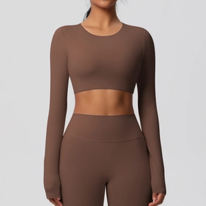 Détail du haut court de yoga à manches longues marron et du legging de sport taille haute