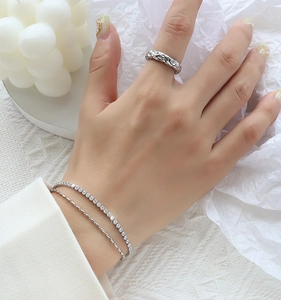 Detail of silver layered bracelet with cubic zirconia and hammered textured ring