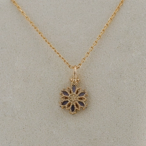 Détail macro du pendentif fleur plaqué or 14K avec tanzanites bleues et bordures perlées