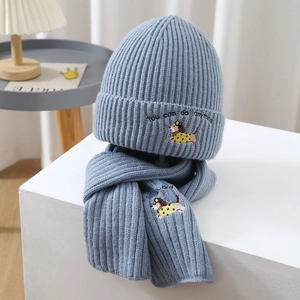 Detail of grey-blue knit hat and scarf set featuring cartoon puppy embroidery pattern