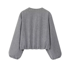 Détail du blouson aviateur gris montrant le tissu en maille douce et les poignets côtelés