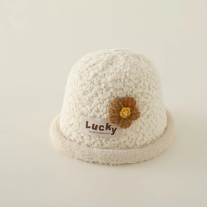 Detailansicht eines beigen Teddy-Fischerhutes für Kinder mit Strickblume und Label