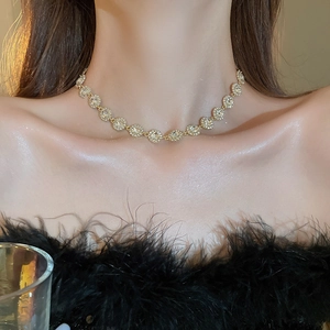 Détail d'un collier plaqué or avec des cercles pavés étincelants sur le cou du mannequin