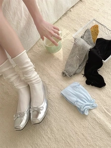 Dettaglio di calze al polpaccio in maglia stile balletto con fiocchi e scarpe argento