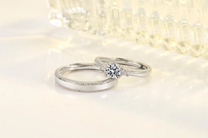 Macro shot of silver moissanite couple rings featuring intricate beaded edge detailing
