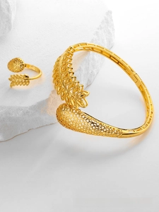 Macro shot of gold-plated leaf bangle and ring set with hollow weave pattern detail