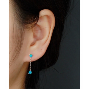 Close-up of 925 sterling silver drop earrings with blue opal tassels on a model