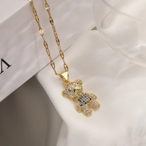 Macro shot of gold plated bear pendant with colorful zircons on a wavy gold chain