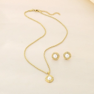 Detailed view of gold twist chain necklace and earrings with pearl and diamond accents