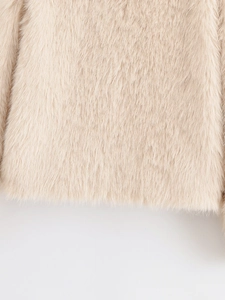 Macro shot of high-density light beige faux fur texture and stitching on the hem