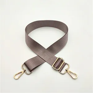 Adjustable taupe nylon shoulder strap with gold metal lobster clasps and buckle