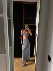Détail d'un crop top à carreaux noir et blanc et d'une jupe longue ajustée assortie