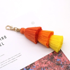 Dreilagiger Schlüsselanhänger mit orange-gelben Fransen und goldenem Verschluss
