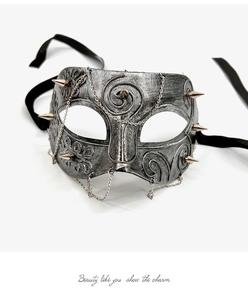 Detailed close-up of vintage punk half-face mask with silver spikes and hanging chains