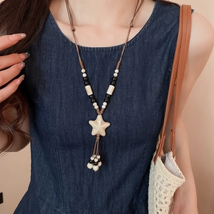 Detail of bohemian starfish pendant with tassels and woven beads on a wax cord necklace