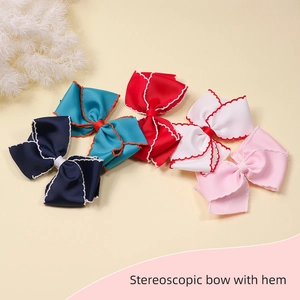 Detail showing five stereoscopic hair bows with contrast hem in navy, green, red, and pink